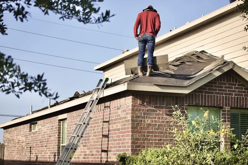 Professional roofer working on a residential roof in Capital District